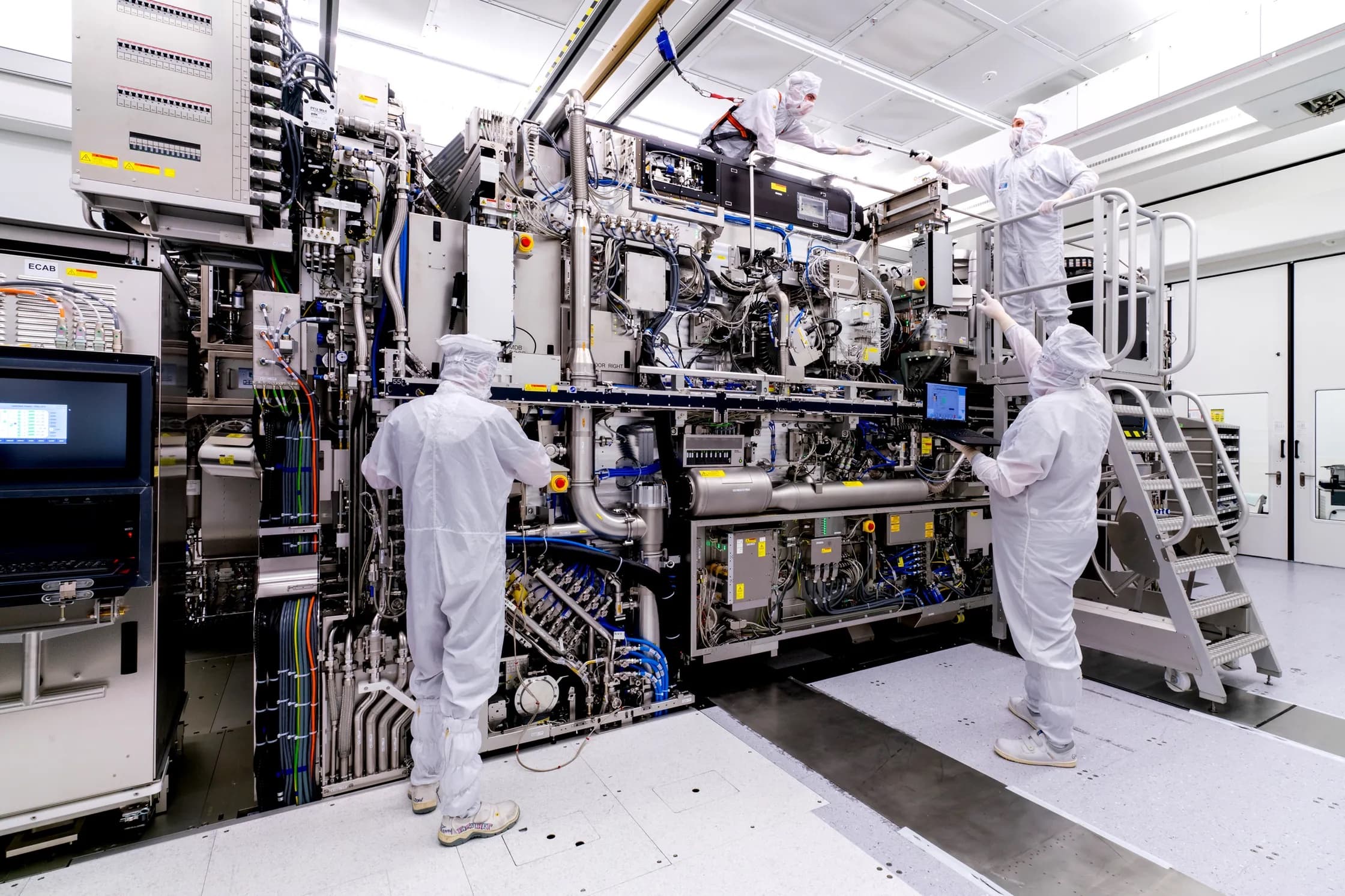 ASML technicians in clean suits assembling an extreme ultraviolet lithography system in the Veldhoven cleanroom
