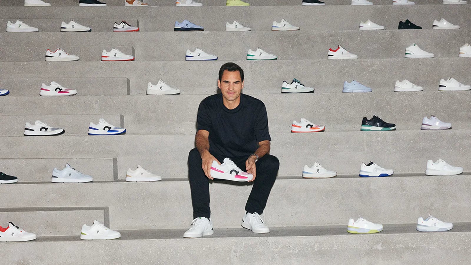 Roger Federer sitting on concrete steps surrounded by On Running The Roger sneakers in multiple colorways — On Holding brand campaign